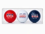 Three commemorative USA 250th Anniversary golf balls in a clear display gift box featuring red, white, and navy patriotic designs with "USA Est. 1776" and "1776–2026 United States of America 250th Anniversary" graphics.
