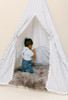 This tent is a black ticking material on white canvas fabric all around. The doors have white pom pom trim.
