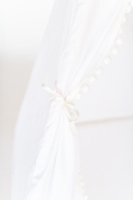 This tent is all white is made of 100% twill cotton fabric and the doors have white pom pom trim.