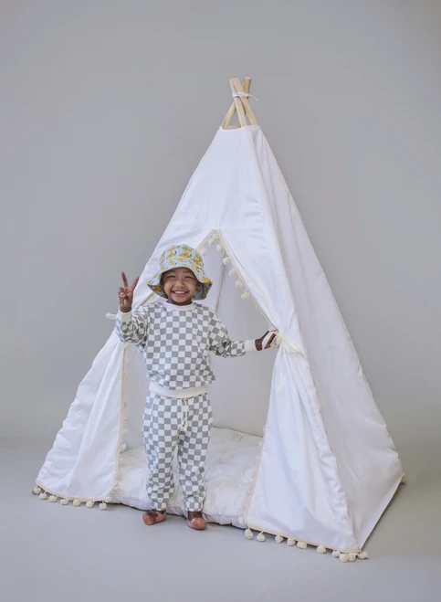 The Skylar tent is made from white twill cotton with cream pom poms on the front panels.