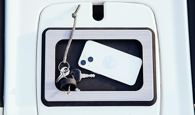 Phone and pair of keys sitting inside of SeaDek accessories holder on a boat