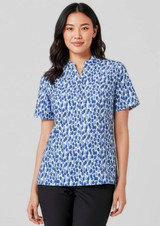 A woman wearing a short-sleeved tunic in a blue stardust print, featuring a collar and a relaxed fit.