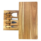 A wooden cheeseboard with a smooth finish, featuring four stainless steel knives in a fitted tray.