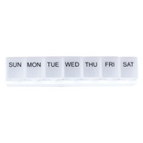 A white weekly pill organiser with compartments labelled for each day of the week. It features a simple branding logo.