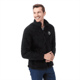 A men's black soft shell jacket with a textured finish and a logo on the chest, worn by a smiling model.