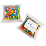 A pillow pack containing multicoloured chocolate beans, featuring a branded sticker on the front.