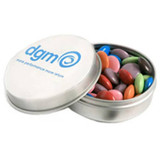 A silver tin containing colourful choc beans, featuring a logo on the lid.