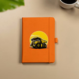 An orange hard-bound journal featuring an illustration of a dump truck, with an elastic closure.