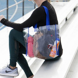 A clear tote bag with blue straps, containing a drink bottle, sunscreen, a hat, and various personal items.