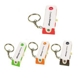 A keychain light in four colours: green, orange, white, and black, featuring a small branding logo.