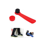 A red shoe horn with a brush cap. The brush is black and the horn is smooth. Includes a container for storage.