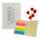 A sticky note pad with a speckled cover featuring a logo, containing colourful sticky notes in pink, orange, green, and yellow.