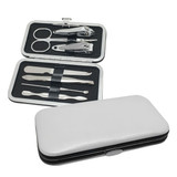 A silver and black manicure set with various tools, including nail clippers, scissors, and tweezers, in a sleek case.