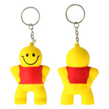 A yellow stress keyring shaped like a little man with a red shirt, featuring a smiling face and a metal keychain.