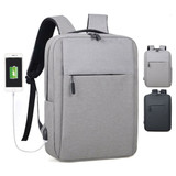 A grey backpack with a front pocket, featuring a USB charging port and black straps, with a logo on the side.