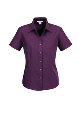 A purple short sleeve button-up shirt with a collared neckline and a fitted style, featuring a logo.