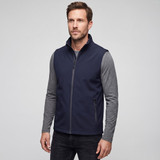 A man wearing a navy blue softshell vest over a grey long-sleeve shirt, with a zipper and side pockets.