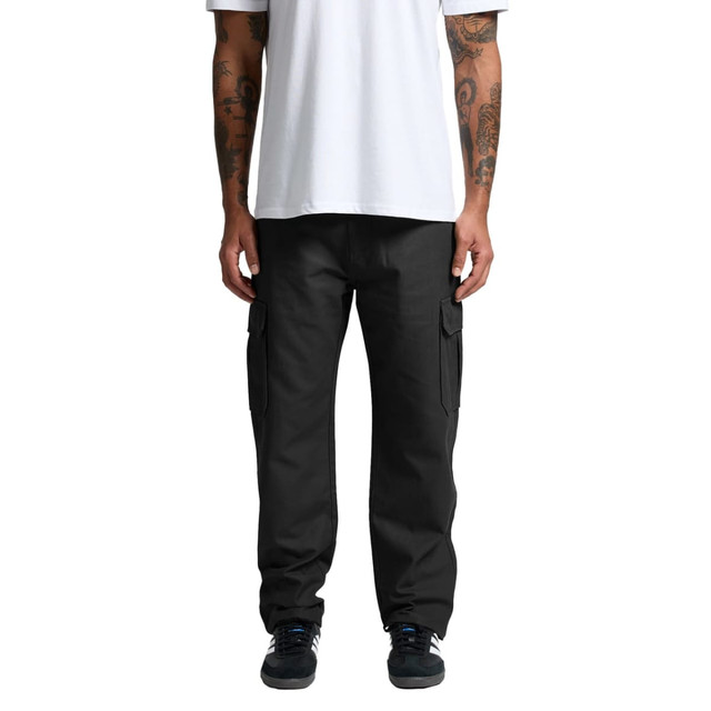 Utility cargo pants in black, featuring side pockets, worn by a person standing with tattoos visible.