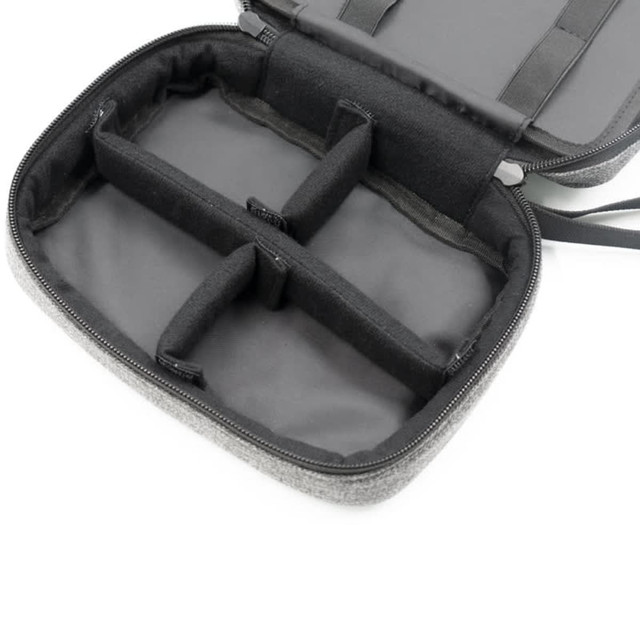 A grey toiletry bag featuring multiple compartments, with a zippered closure and an interior lining.