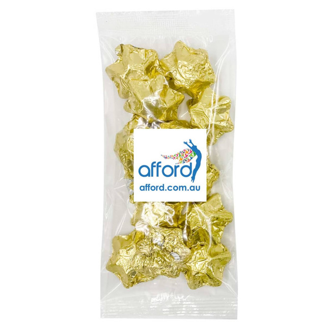 A clear package containing gold foil-wrapped star-shaped chocolates. The pack features a logo on the front. A clear package containing gold foil-wrapped star-shaped chocolates. The pack features a logo on the front.