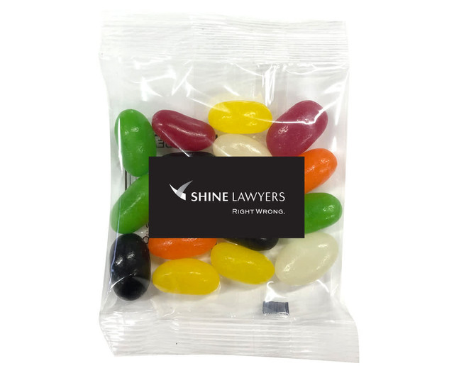 A pack of Aussie Jelly Beans contains various colours including red, green, yellow, black, and white. It has a logo on the packaging. A pack of Aussie Jelly Beans contains various colours including red, green, yellow, black, and white. It has a logo on the packaging.