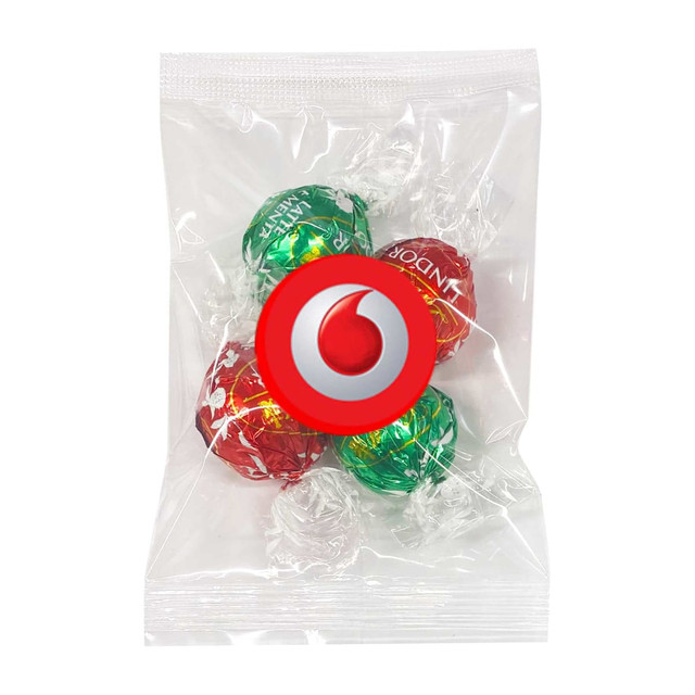 A sealed bag containing four Lindt chocolate balls in red and green wrappers, featuring a logo on the packaging. A sealed bag containing four Lindt chocolate balls in red and green wrappers, featuring a logo on the packaging.