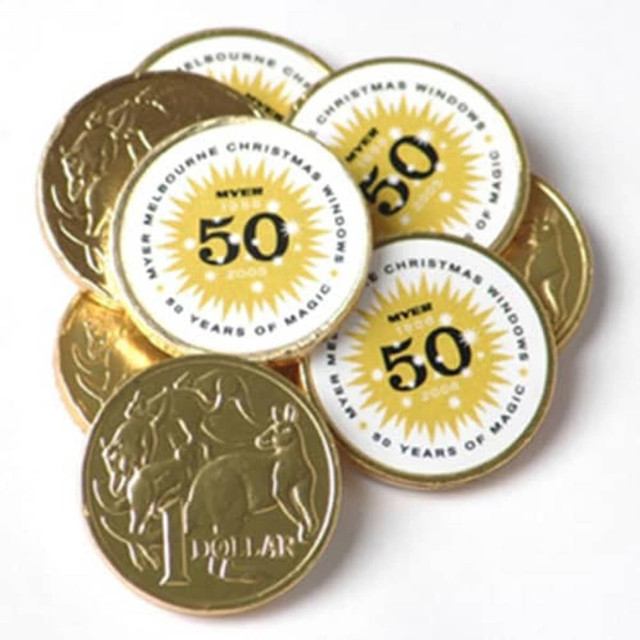 Gold chocolate coins with full colour stickers adhered, featuring various designs and a logo, stacked together.