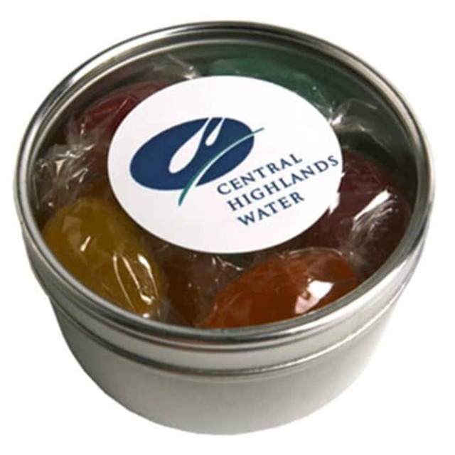 A small round silver tin containing boiled lollies in various colours, sealed with a clear plastic wrap.