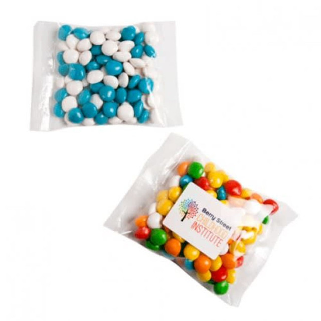 A clear bag containing colourful chewy fruit candies in blue, white, yellow, green, and orange, with a label.