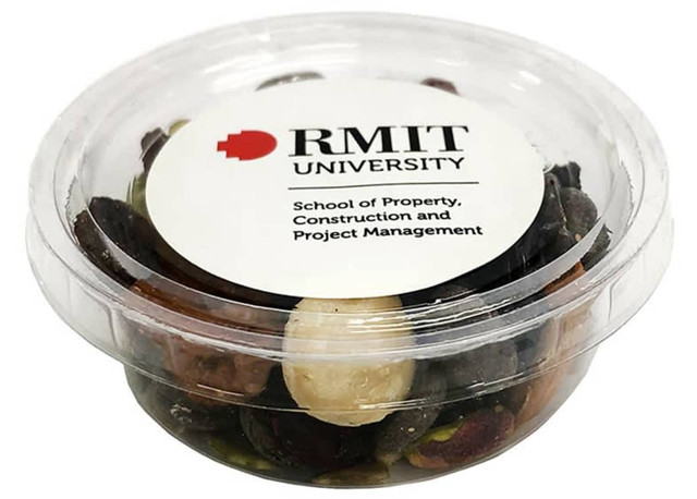 A clear container filled with a mix of nuts and dried fruits, featuring a logo on the lid.