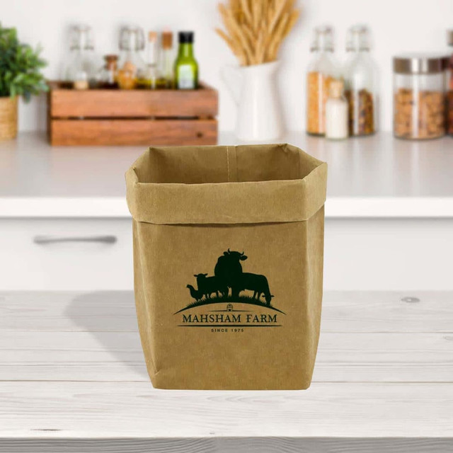 A large kraft paper storage bag in brown, featuring a logo, placed on a kitchen countertop with various jars.