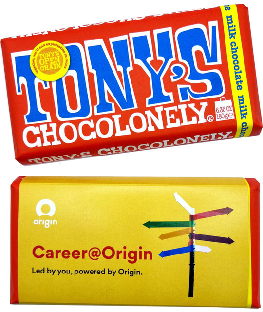 A rectangular chocolate bar with a red and yellow sleeve, featuring milk chocolate and a logo.
