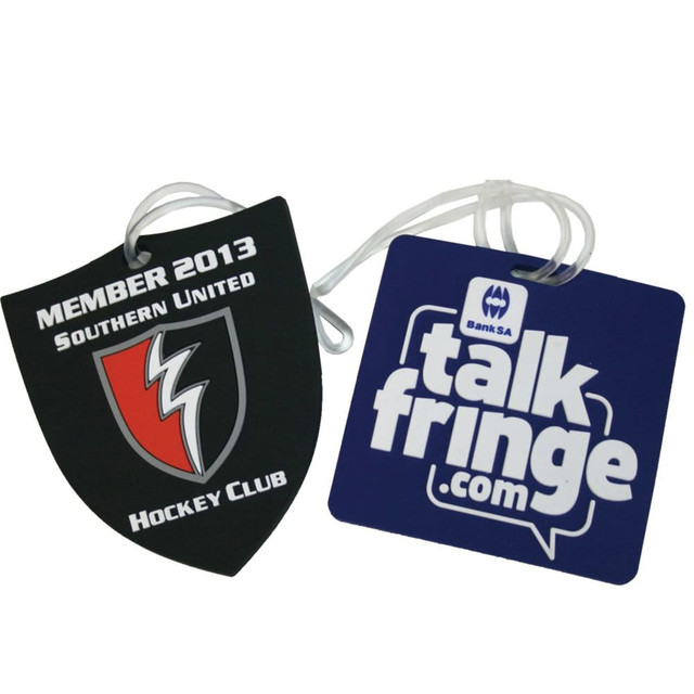 Custom-shaped PVC luggage tags featuring a shield design in black and a square design in blue, each with a logo. Custom-shaped PVC luggage tags featuring a shield design in black and a square design in blue, each with a logo.