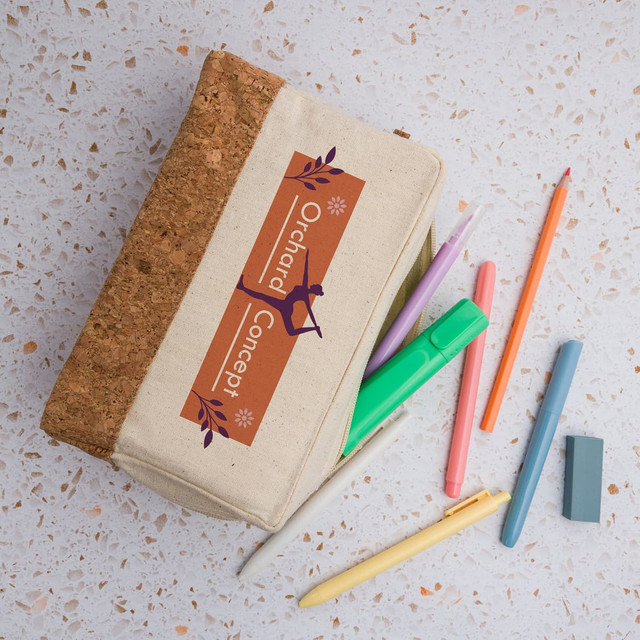 A cork and beige utility case with colorful pens and pencils scattered around it. The case has a logo on it. A cork and beige utility case with colorful pens and pencils scattered around it. The case has a logo on it.