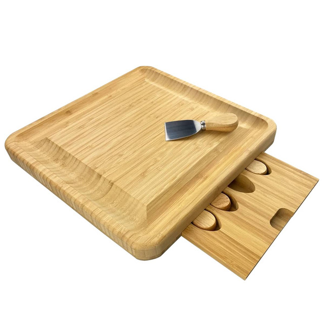 A wooden cheeseboard with a knife and a drawer for storing additional utensils. The set is made from bamboo.
