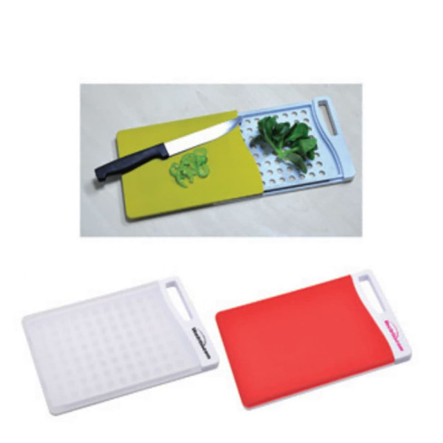 A set of chopping boards in white, red, and green, featuring a knife and chopped vegetables on one board.