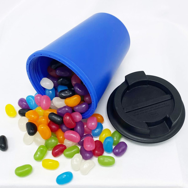 A drink bottle in blue with a black lid, surrounded by colourful jelly beans in various shapes and sizes.
