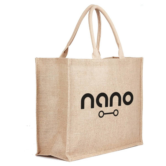 A beige jute bag with two handles and a logo on one side. Ideal for reusable grocery shopping.
