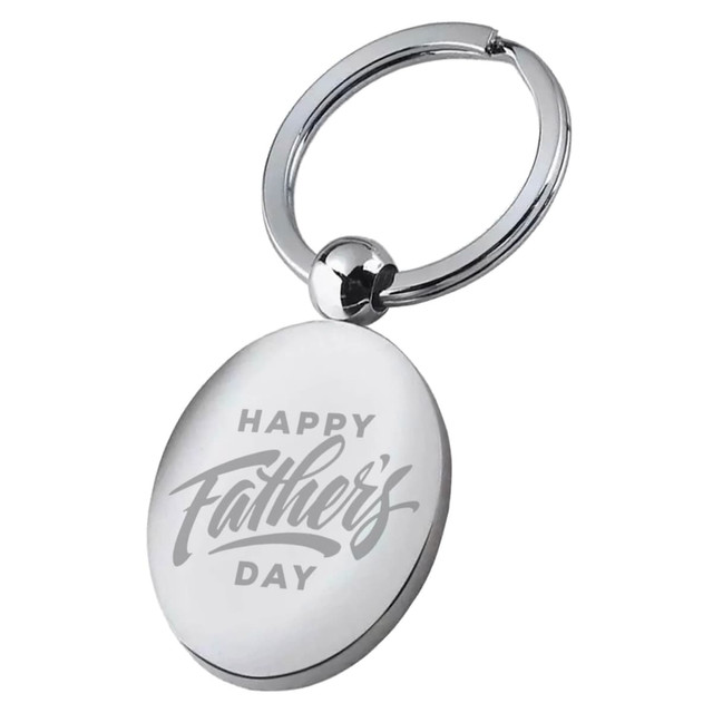 A silver key ring with an oval pendant featuring an engraved message celebrating Father's Day.