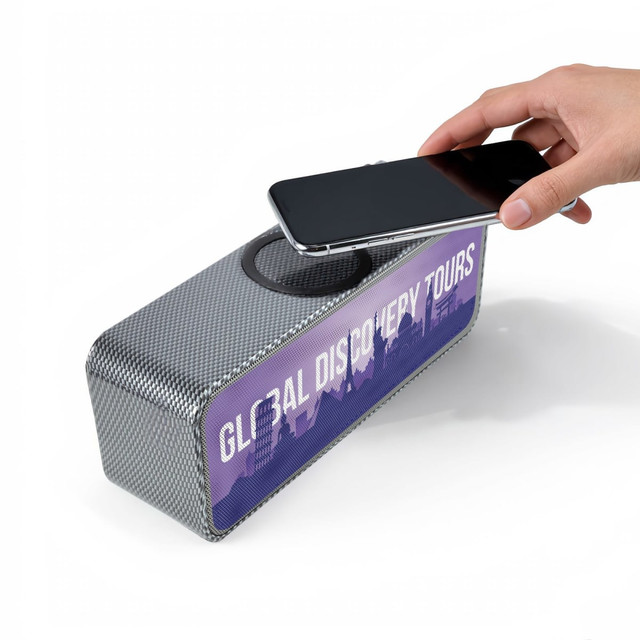A rectangular speaker in grey with a hand placing a smartphone on top for induction charging.
