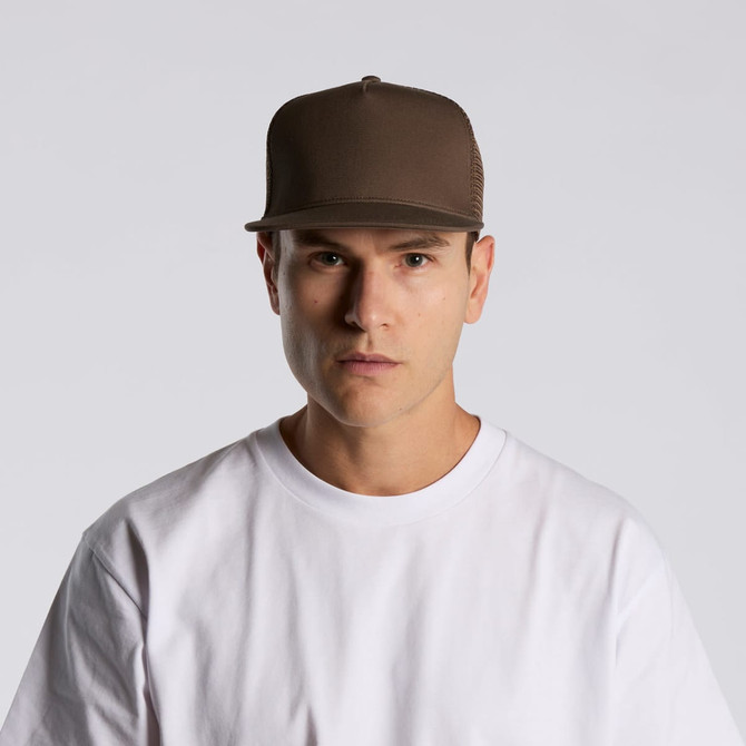 A brown trucker cap with a mesh back, worn by a model in a white t-shirt, facing forward.