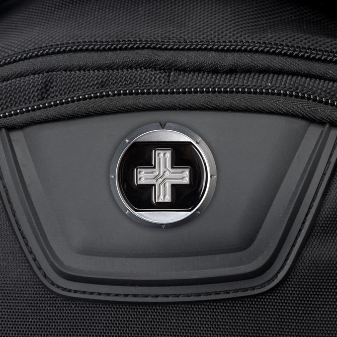 A close-up of a black backpack featuring a round logo on a zippered pocket.