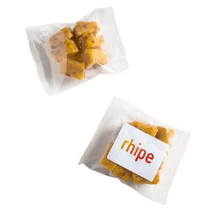 A pack of apricot bites featuring orange-yellow pieces in a clear wrapper, with a logo on the packaging.