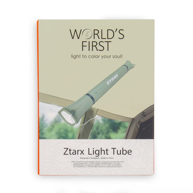 A green foldable camp light is displayed against a natural background, featuring a logo on the product.