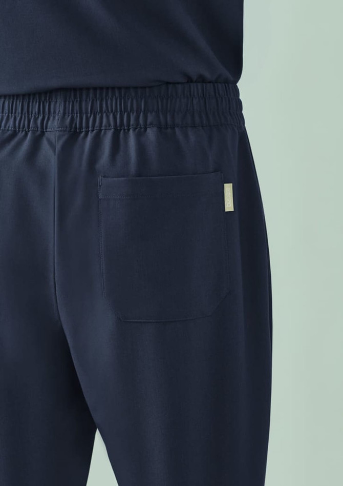 Unisex pulse straight leg scrub pant in navy, featuring an elastic waistband and back pocket, with a logo present.