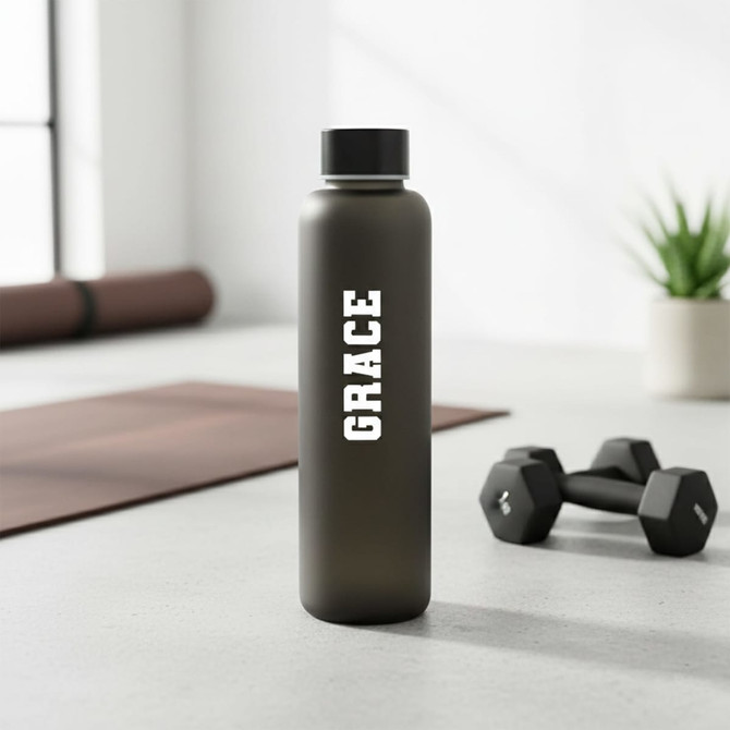 A drink bottle in matte black with a sleek design and white logo, set against a modern backdrop.