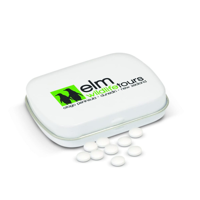 A rectangular white mint tin with a logo on the lid and several white mints scattered around it.