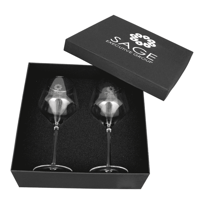 A black box containing two elegant clear wine glasses with gold rims, featuring a logo on each glass.