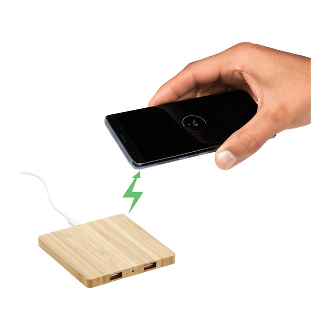 A bamboo wireless charging pad with dual outputs, featuring a sleek design and a hand placing a phone on it.