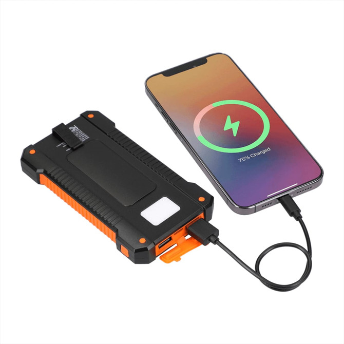 A solar power bank in black and orange connected to a smartphone, showing a charging status display.